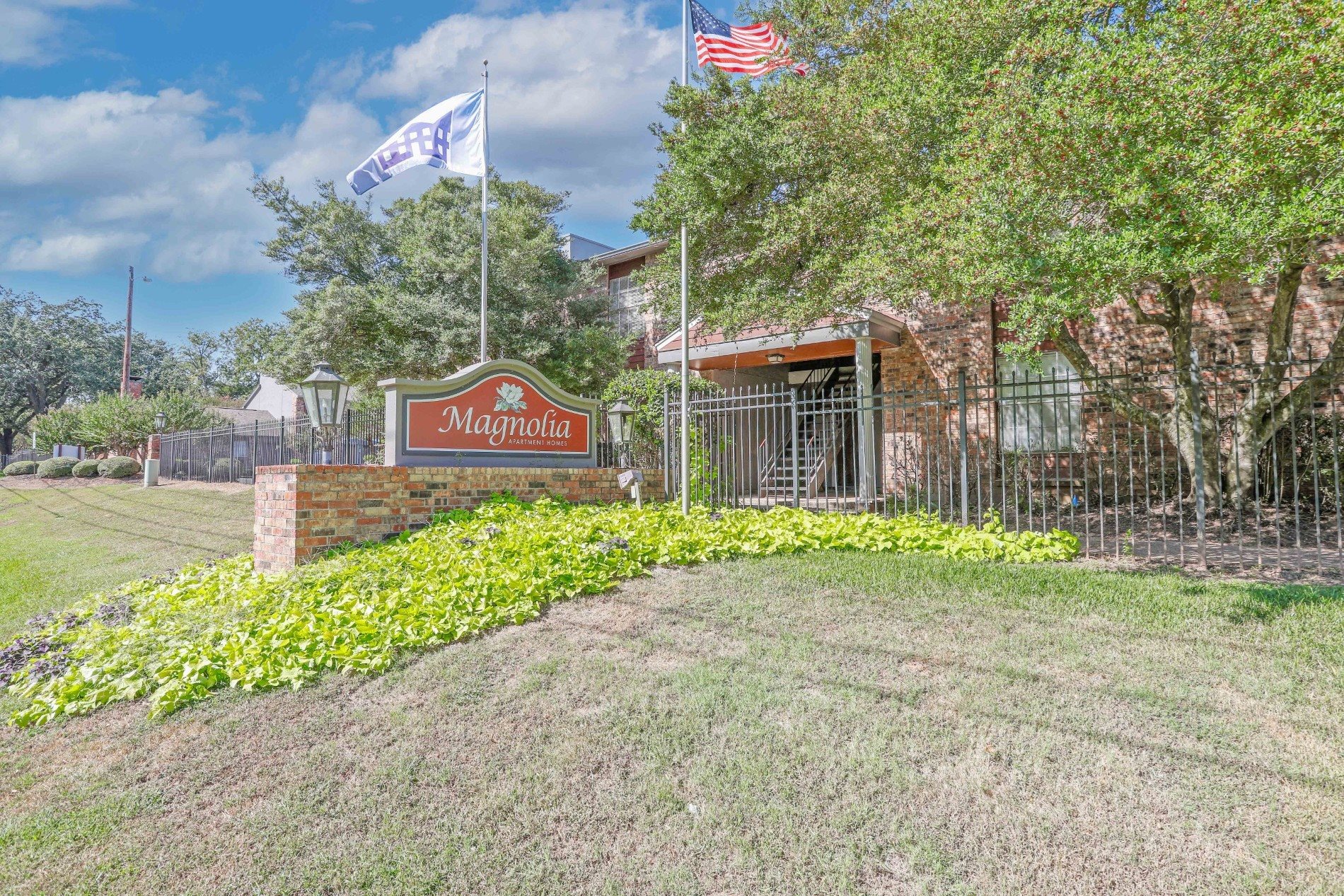 Beautifully maintained grounds in front of our property sign at Magnolia apartments in Shreveport, LA